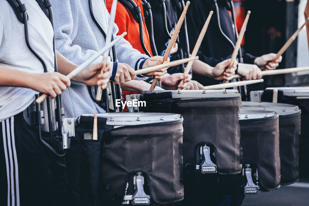 A section of a marching band drum line warming up before rehearsal