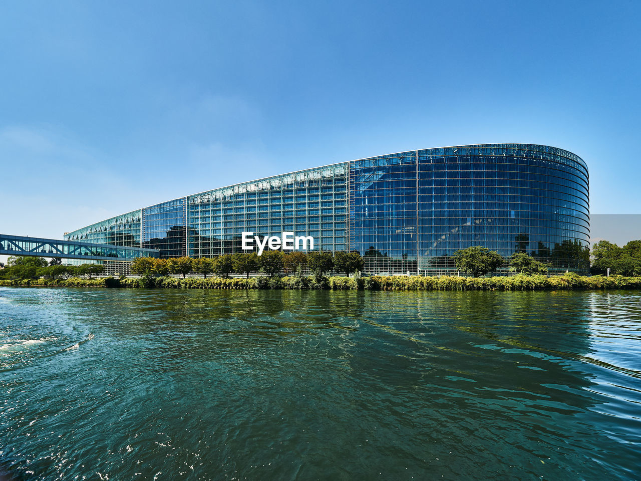 architecture, built structure, reflection, water, building exterior, sky, city, travel destinations, landmark, sea, nature, travel, blue, cityscape, building, tourism, sport venue, outdoors, no people, skyline, stadium, cloud, office building exterior, waterfront, horizon, day, landscape, business, arts culture and entertainment, tree, skyscraper, convention center, clear sky
