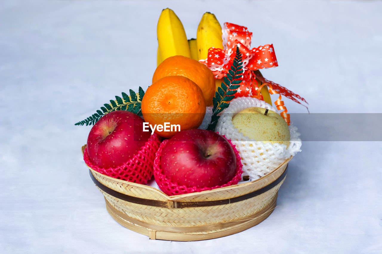 CLOSE-UP OF APPLES IN BASKET ON GLASS