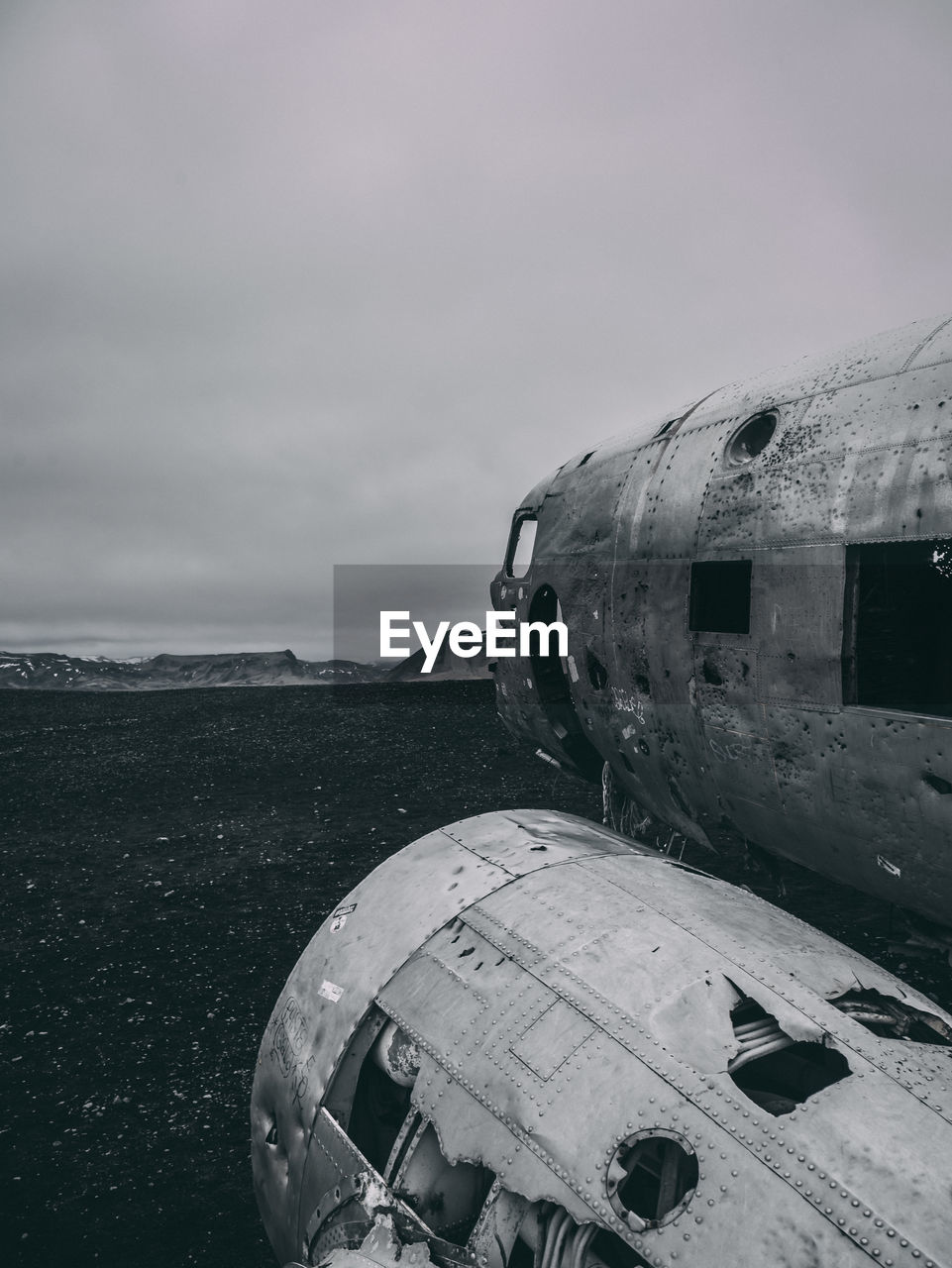 Abandoned airplane on sea shore against sky