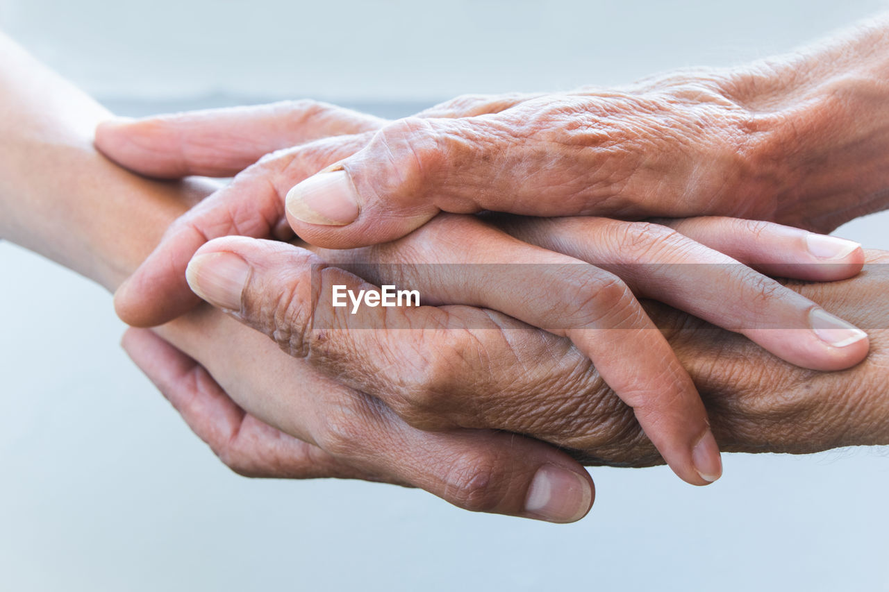 Cropped image of senior people stacking hands outdoors