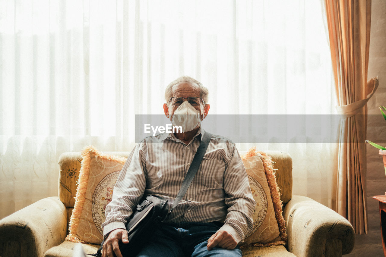 YOUNG MAN SITTING ON SOFA
