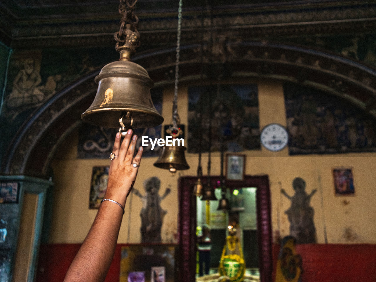 Low angle view of woman hand ringing a bell in the temple