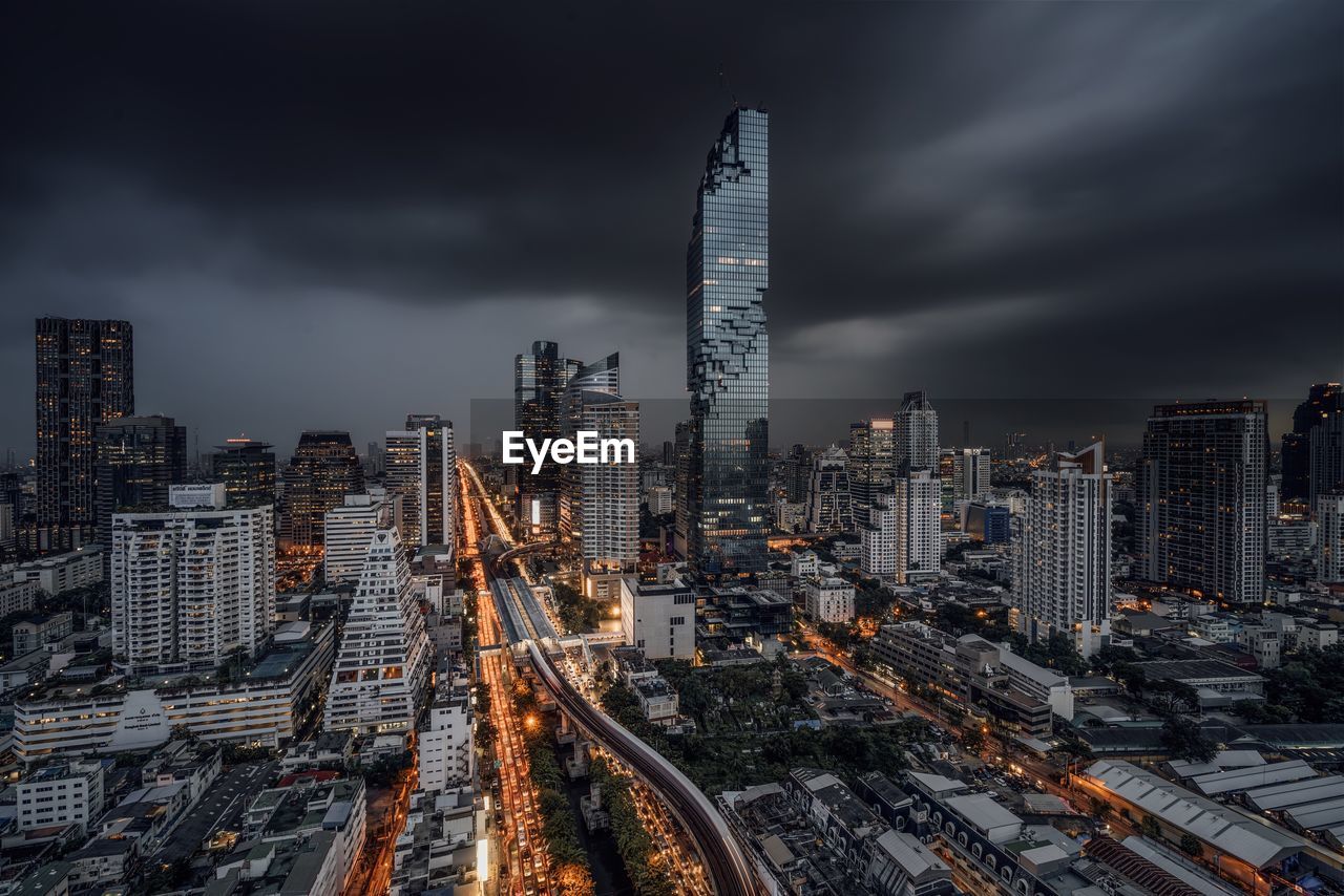 Buildings in city against cloudy sky