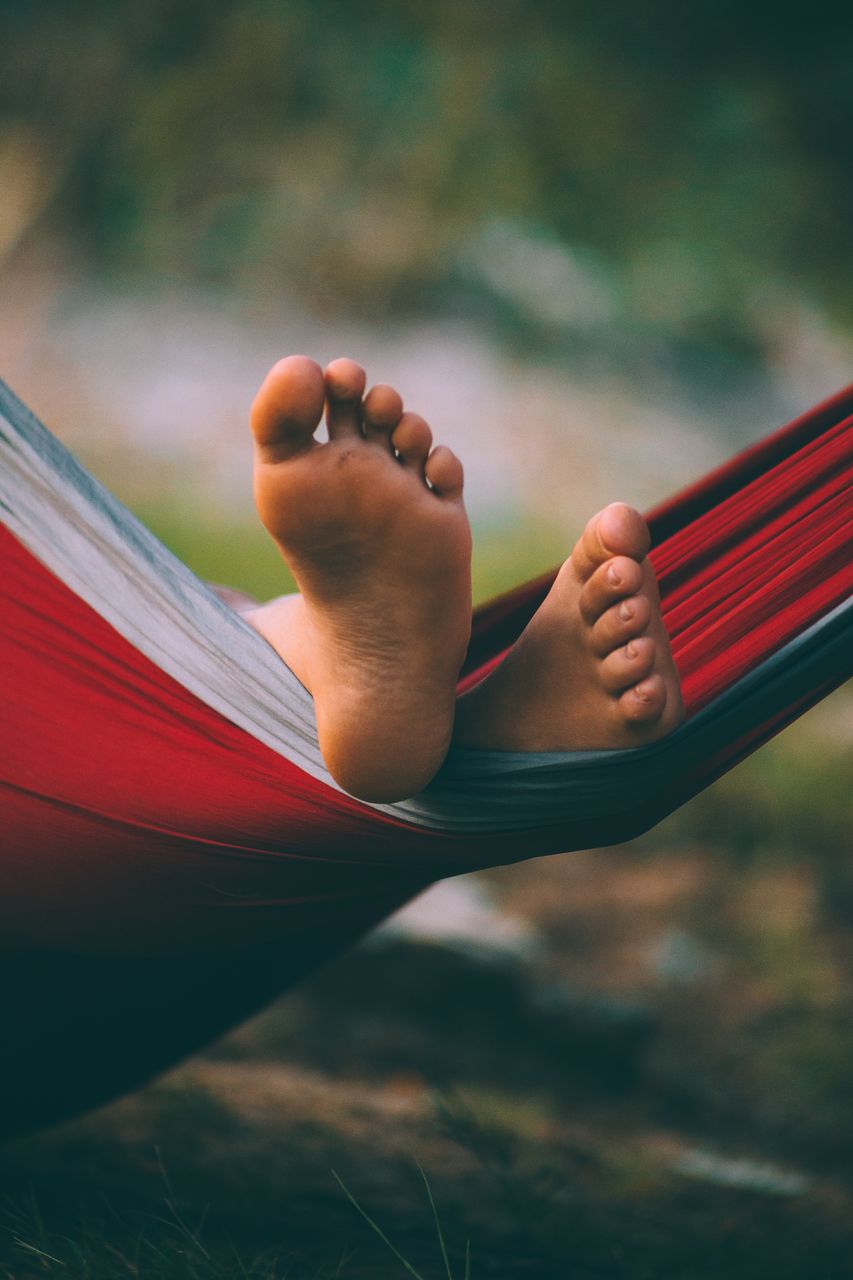 Low section of person relaxing in hammock