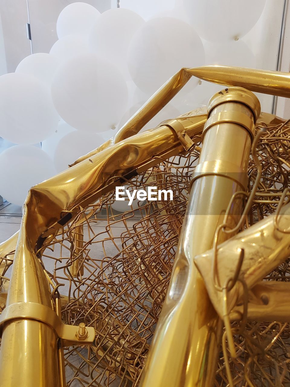 LOW ANGLE VIEW OF YELLOW METAL BASKET ON WICKER