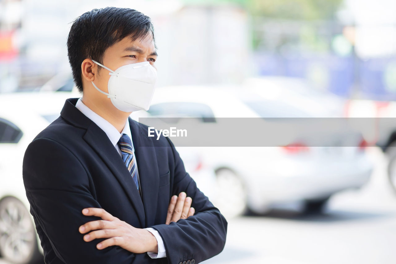 A business man wears a mask to protect corona virus before going to work at the office.