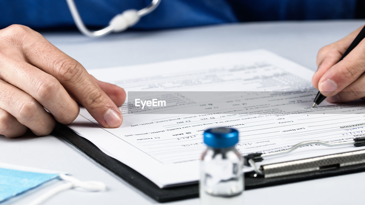 Doctor prepares form for covid vaccination 3rd dose