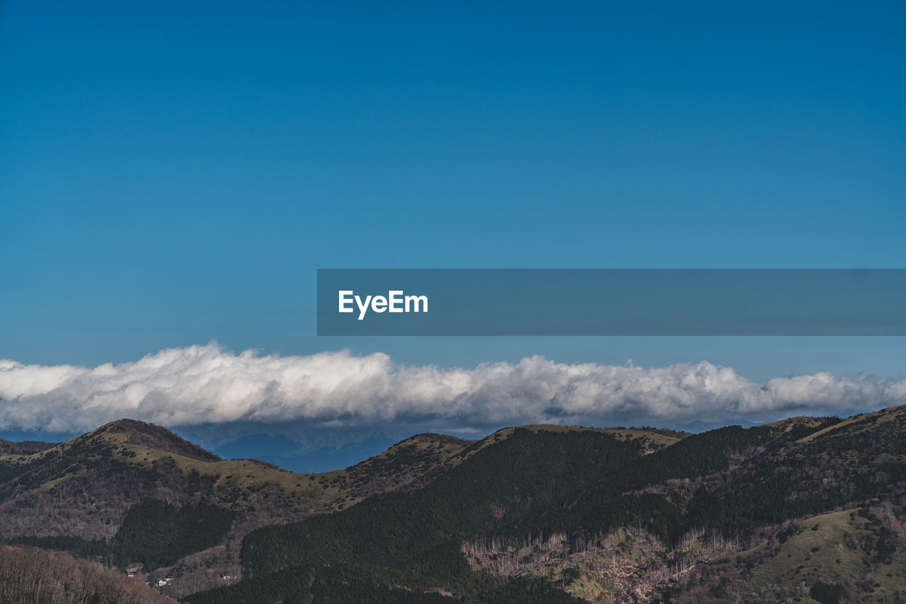 Scenic view of mountains against cloudy sky