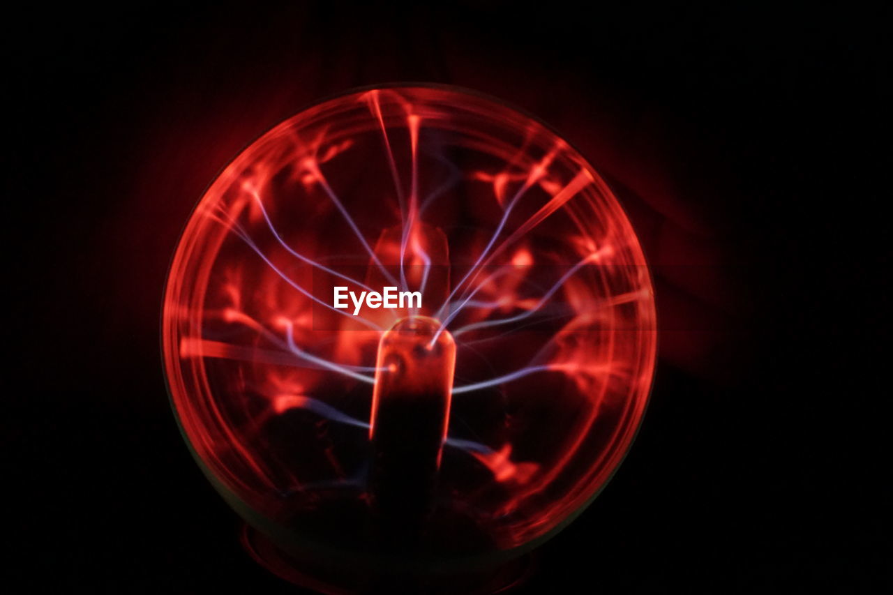 Close-up of red plasma ball against black background
