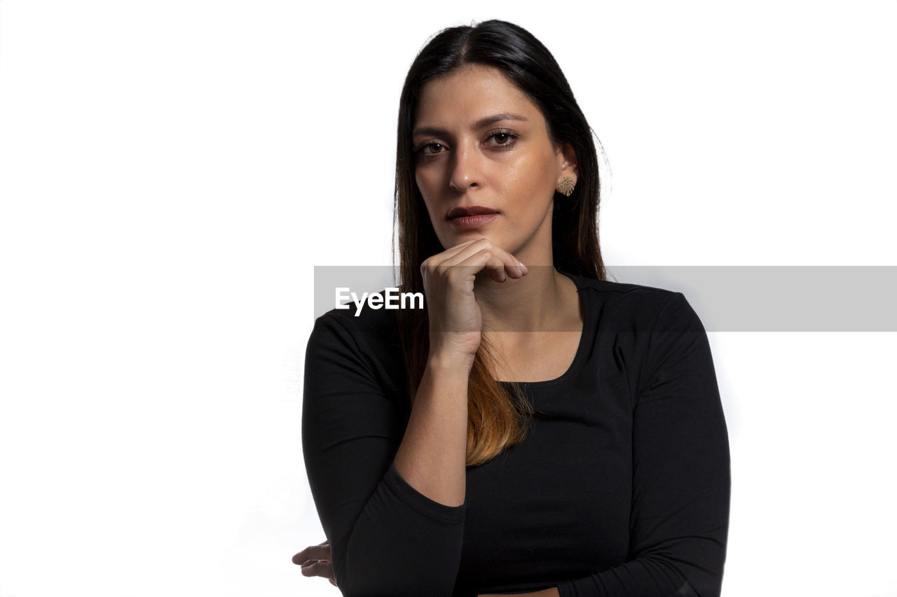 PORTRAIT OF YOUNG WOMAN AGAINST WHITE BACKGROUND