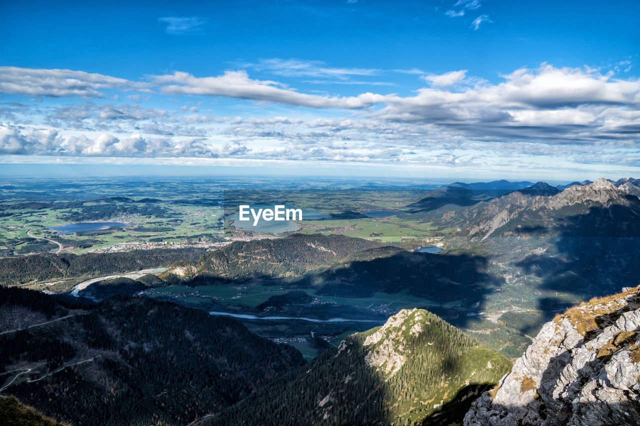 AERIAL VIEW OF SEA AND ROCKY MOUNTAINS AGAINST SKY