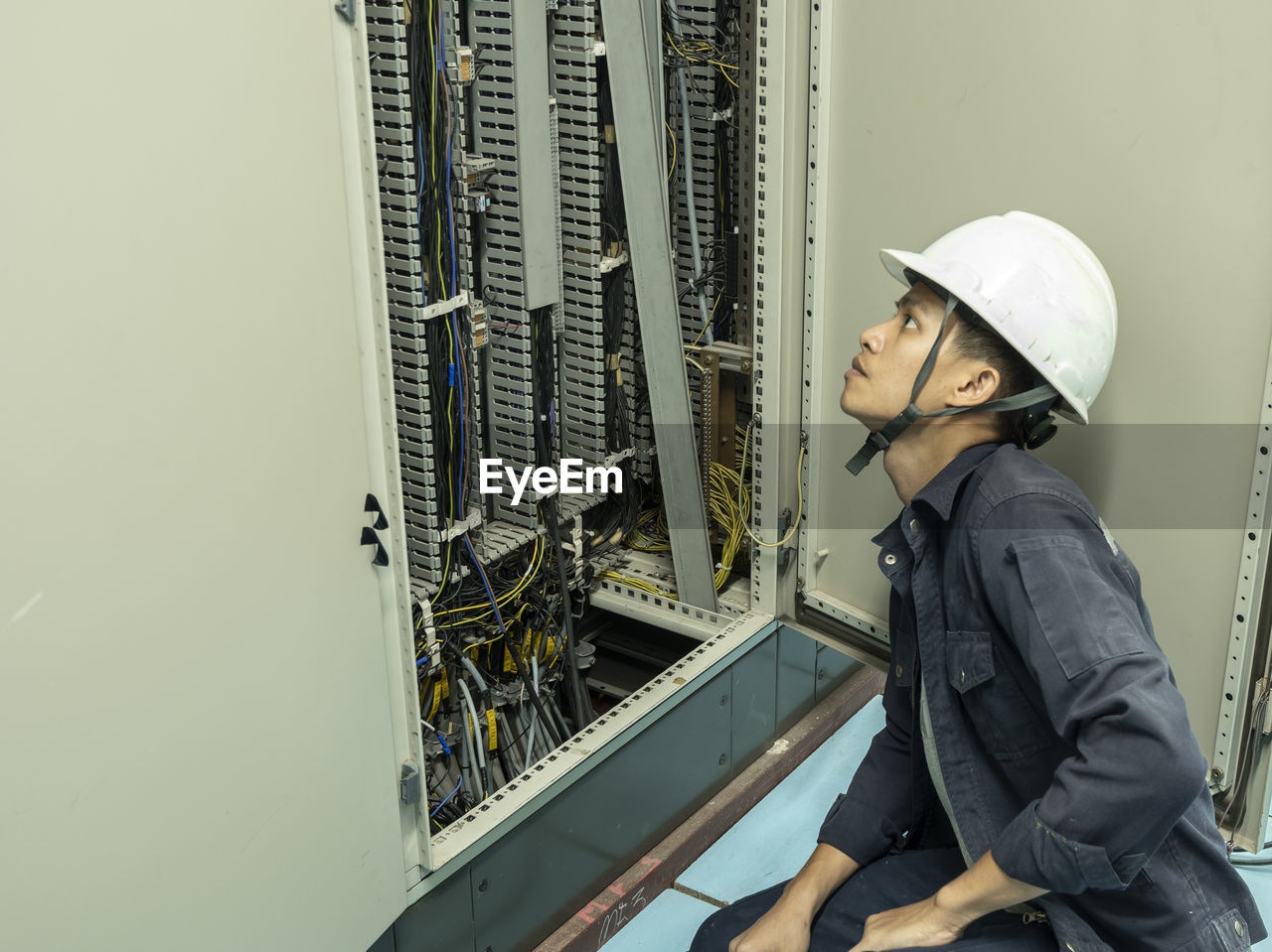 Side view of man working by fuse box