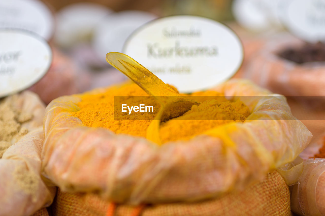 Close-up of bag of yellow spice for sale at market stall