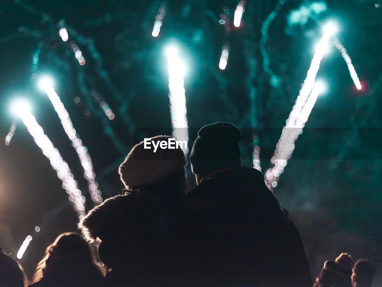 Rear view of couple looking at firework display