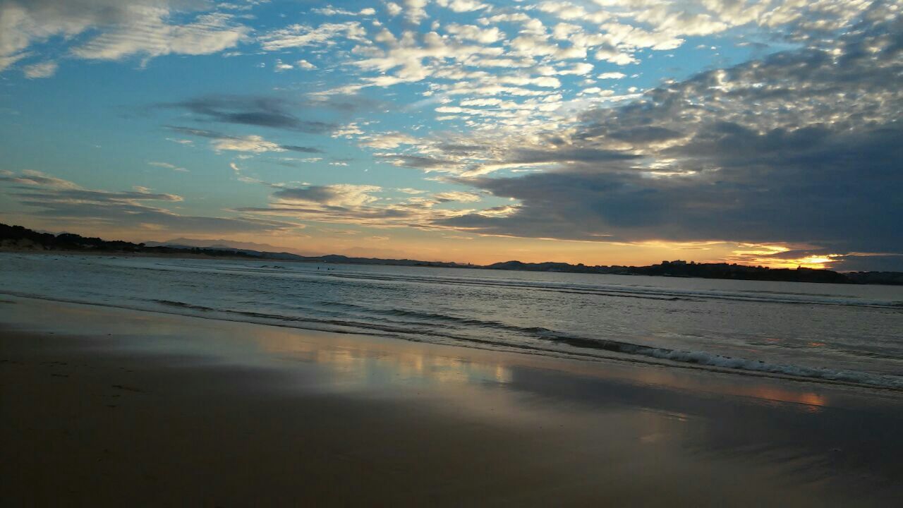 Scenic view of cloudy sky over beach during sunset