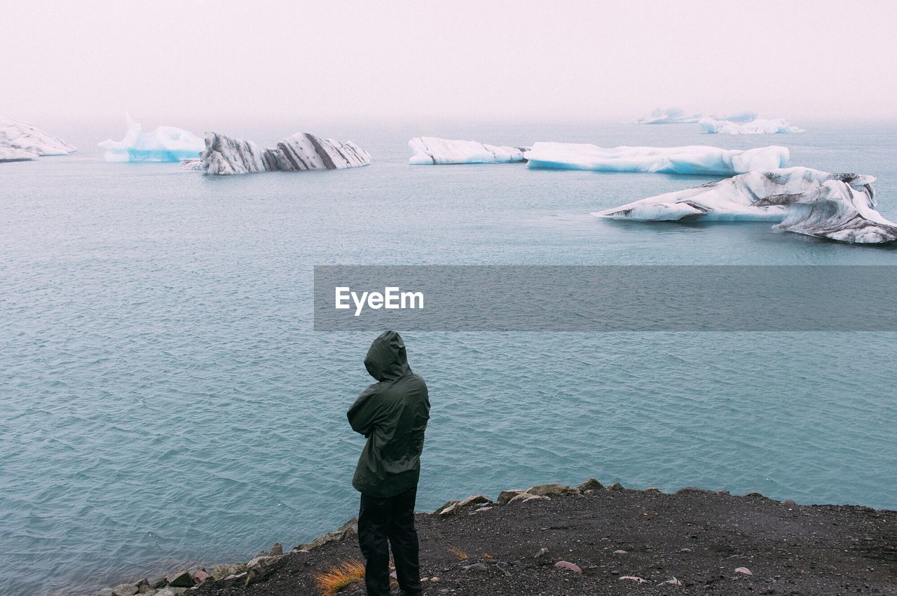 Rear view of man standing in sea