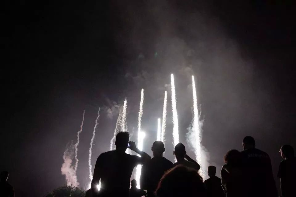 Silhouette people watching sky illumed with fire crackers