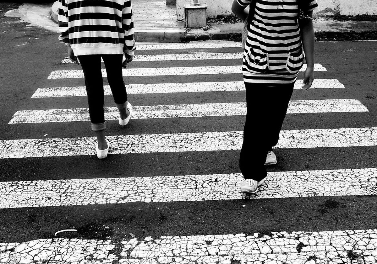 Girls walking on zebra crossing at street