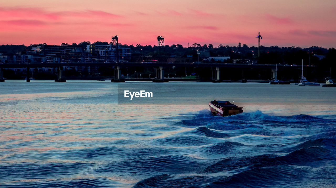 Boat in sea against sky during sunset