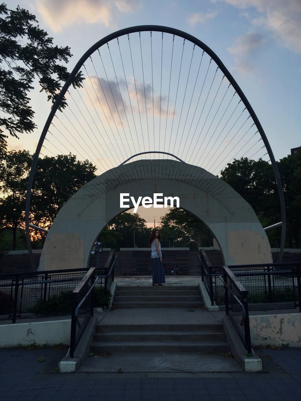 SILHOUETTE OF PEOPLE STANDING ON RAILING
