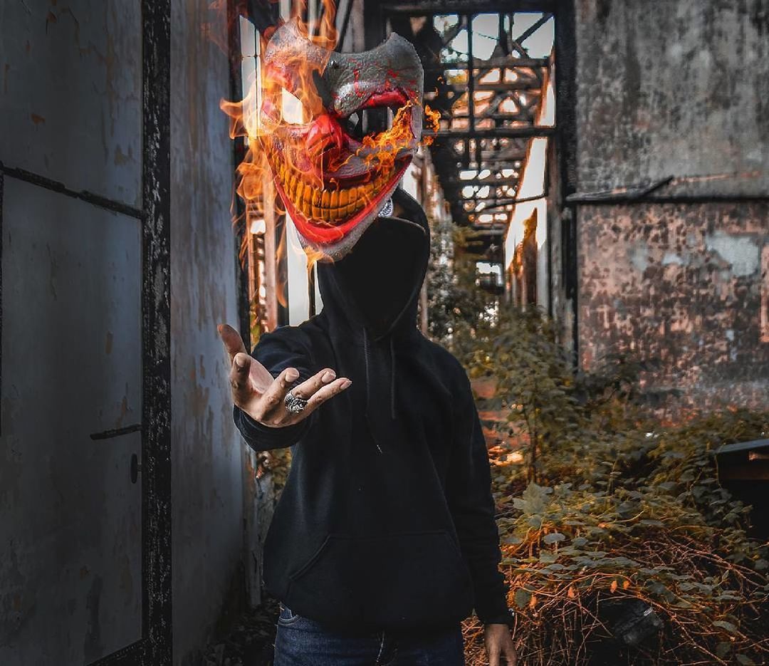 Digital composite image of person catching burning mask