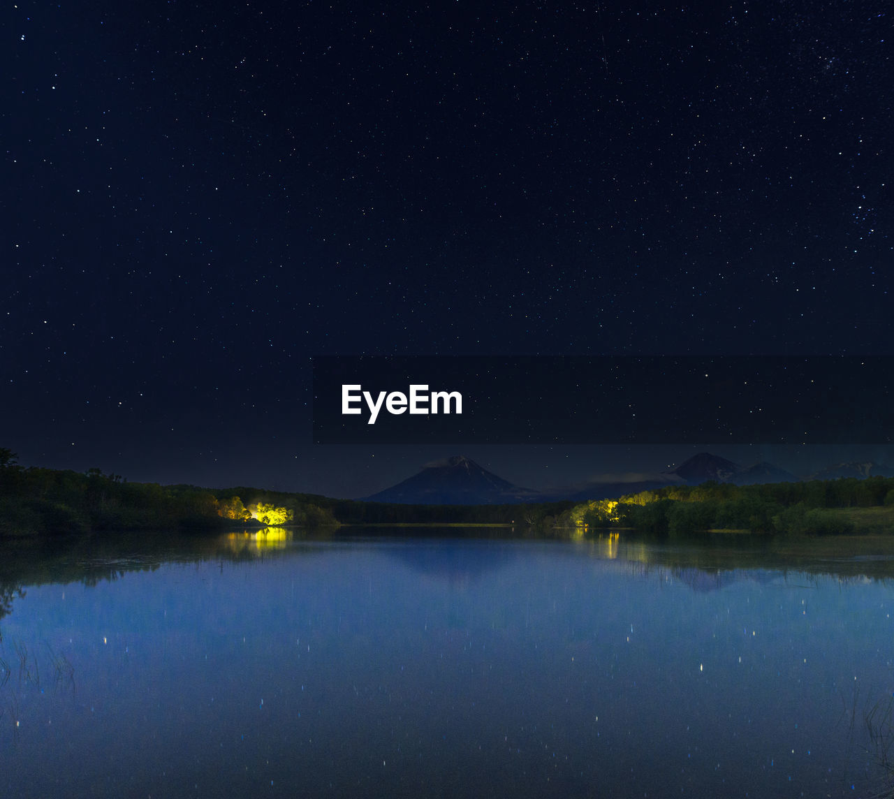 SCENIC VIEW OF LAKE AGAINST MOUNTAIN AT NIGHT