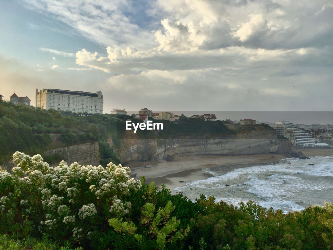 Scenic view of sea by buildings against sky