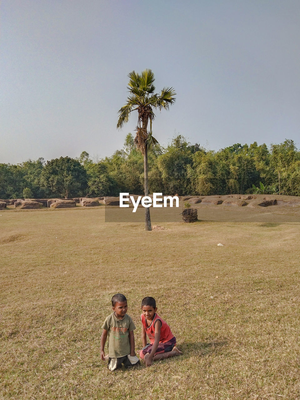 plant, tree, nature, palm tree, land, men, tropical climate, two people, adult, sky, togetherness, field, sitting, women, leisure activity, landscape, day, child, person, childhood, female, agriculture, environment, outdoors, full length, emotion, rural area, casual clothing, family, lifestyles, copy space, bonding, relaxation, beauty in nature, vacation, trip, sunny, holiday, grass, enjoyment, positive emotion, scenics - nature, sunlight