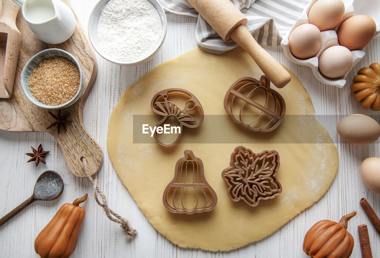 Baking cookies in the form of pumpkin and leaves. cozy autumn pastry. dough with cookie cutters.