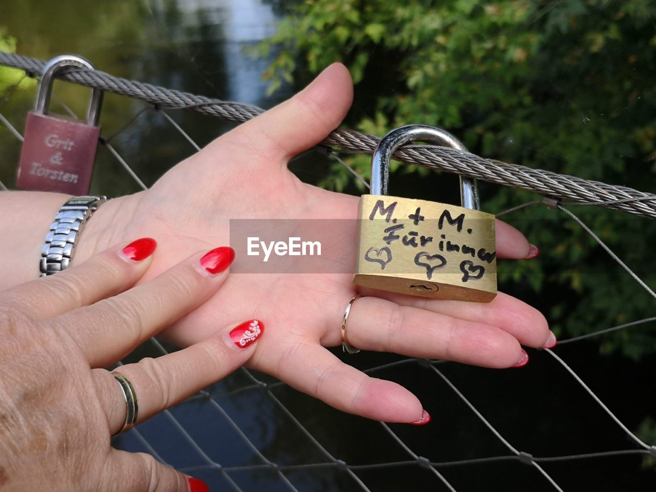 Cropped hands of woman holding padlock with text