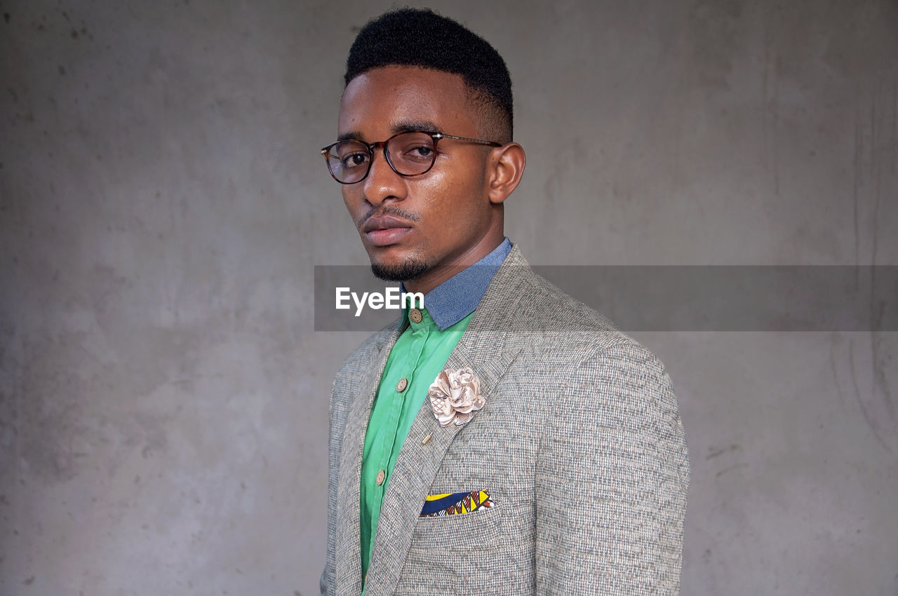 Portrait of young man against wall