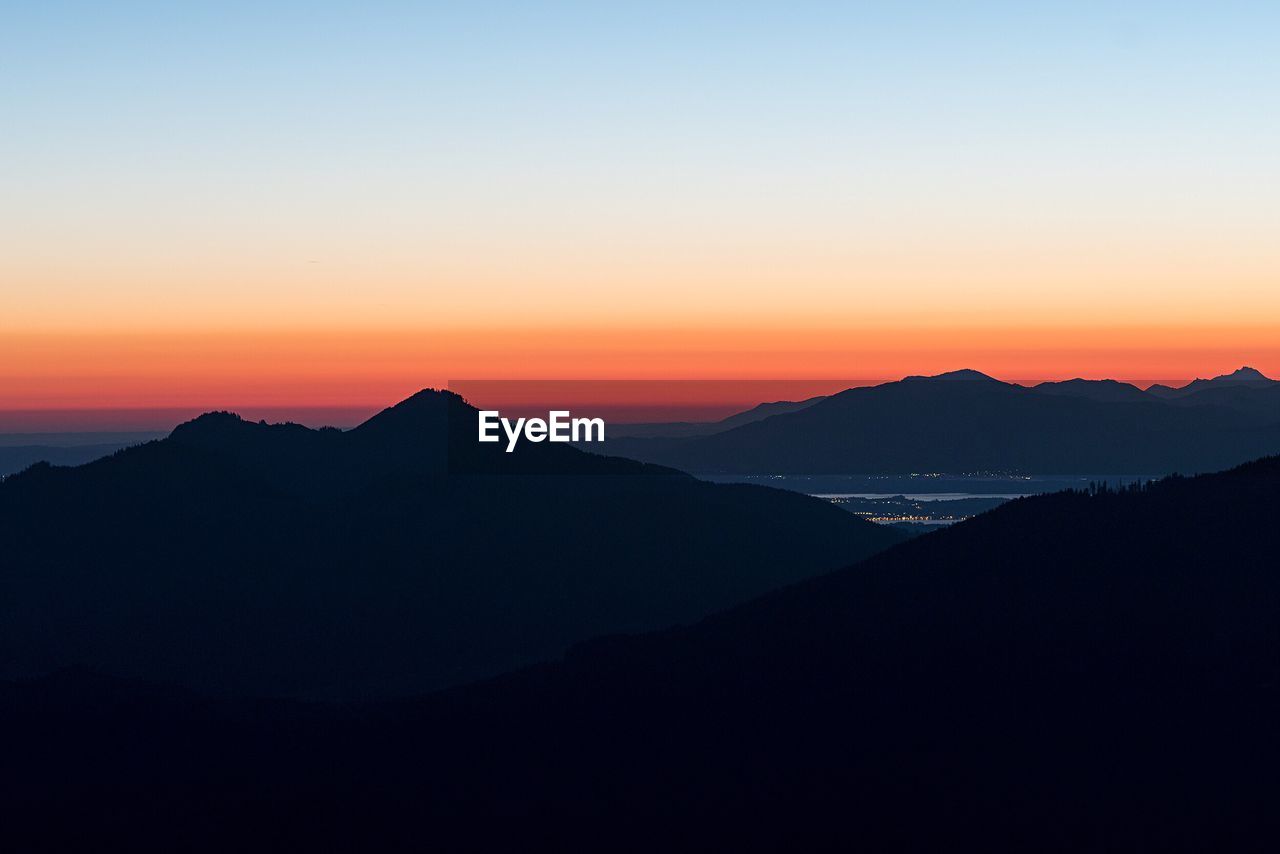 SCENIC VIEW OF SILHOUETTE MOUNTAINS AGAINST SKY AT SUNSET
