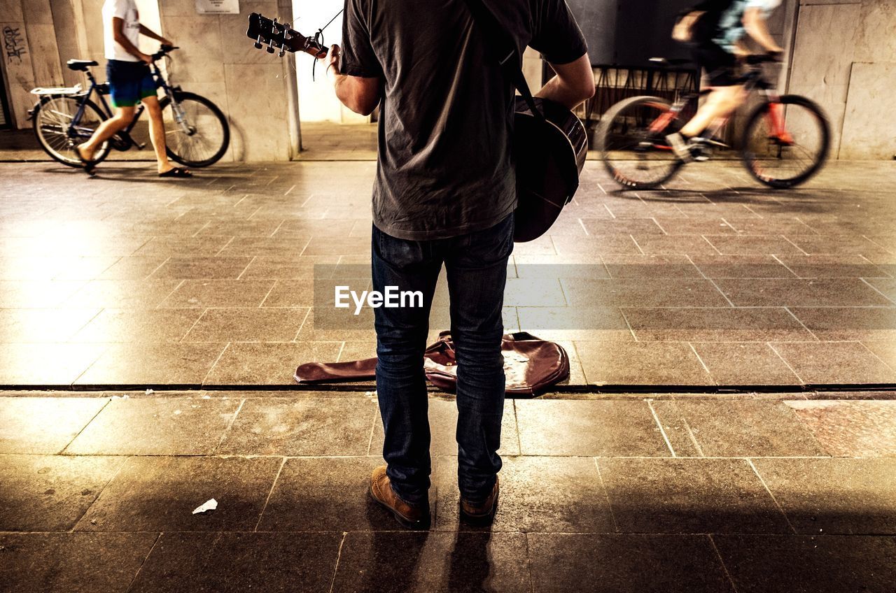 Low section of street musician playing guitar