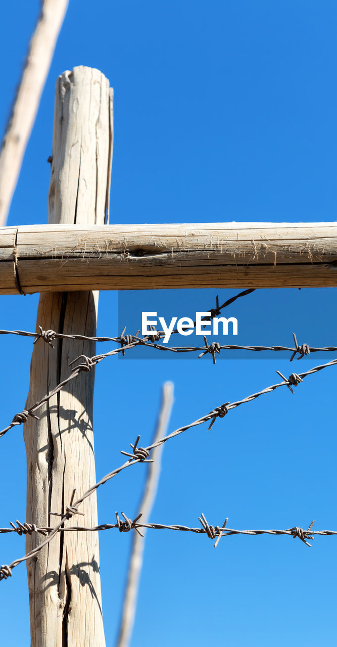 LOW ANGLE VIEW OF BARBED WIRE AGAINST CLEAR SKY