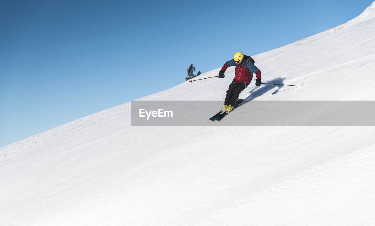 low angle view of man skiing on snow covered landscape