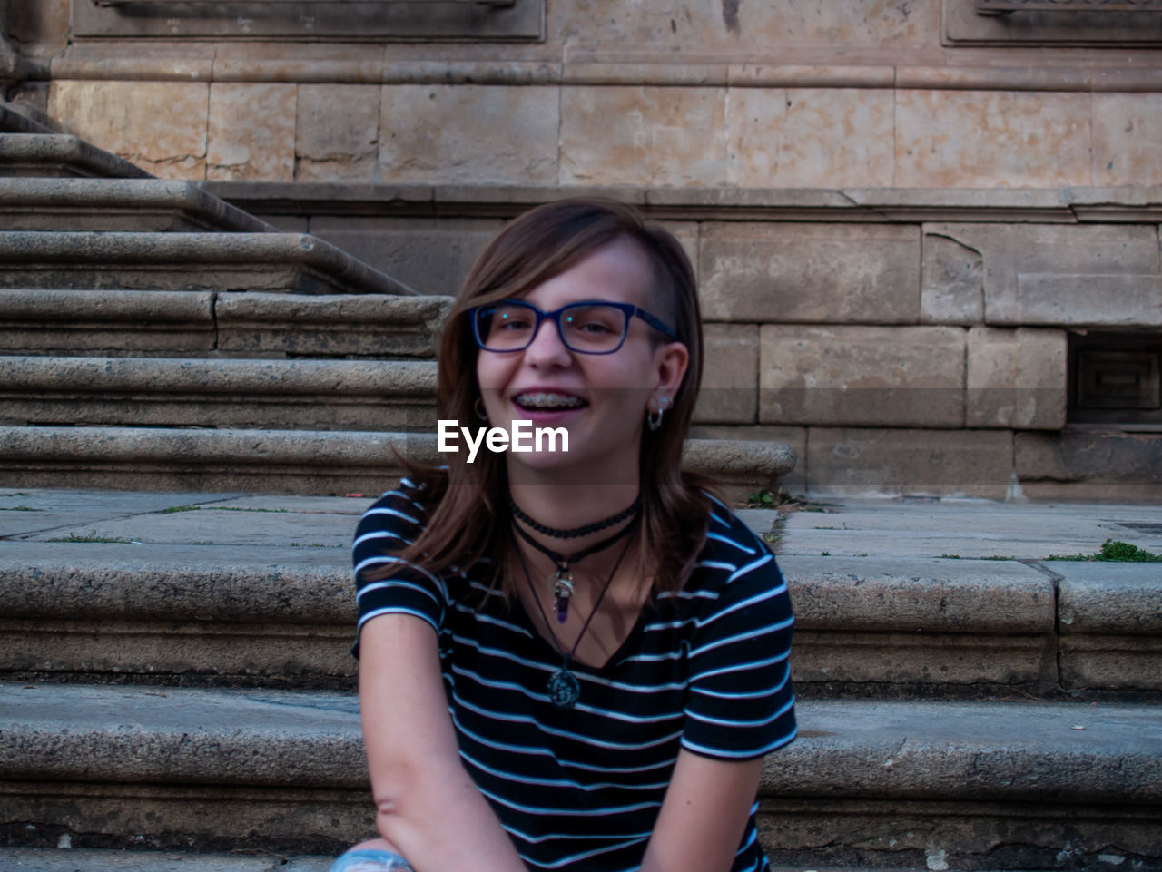 Portrait of smiling teenage girl sitting on steps
