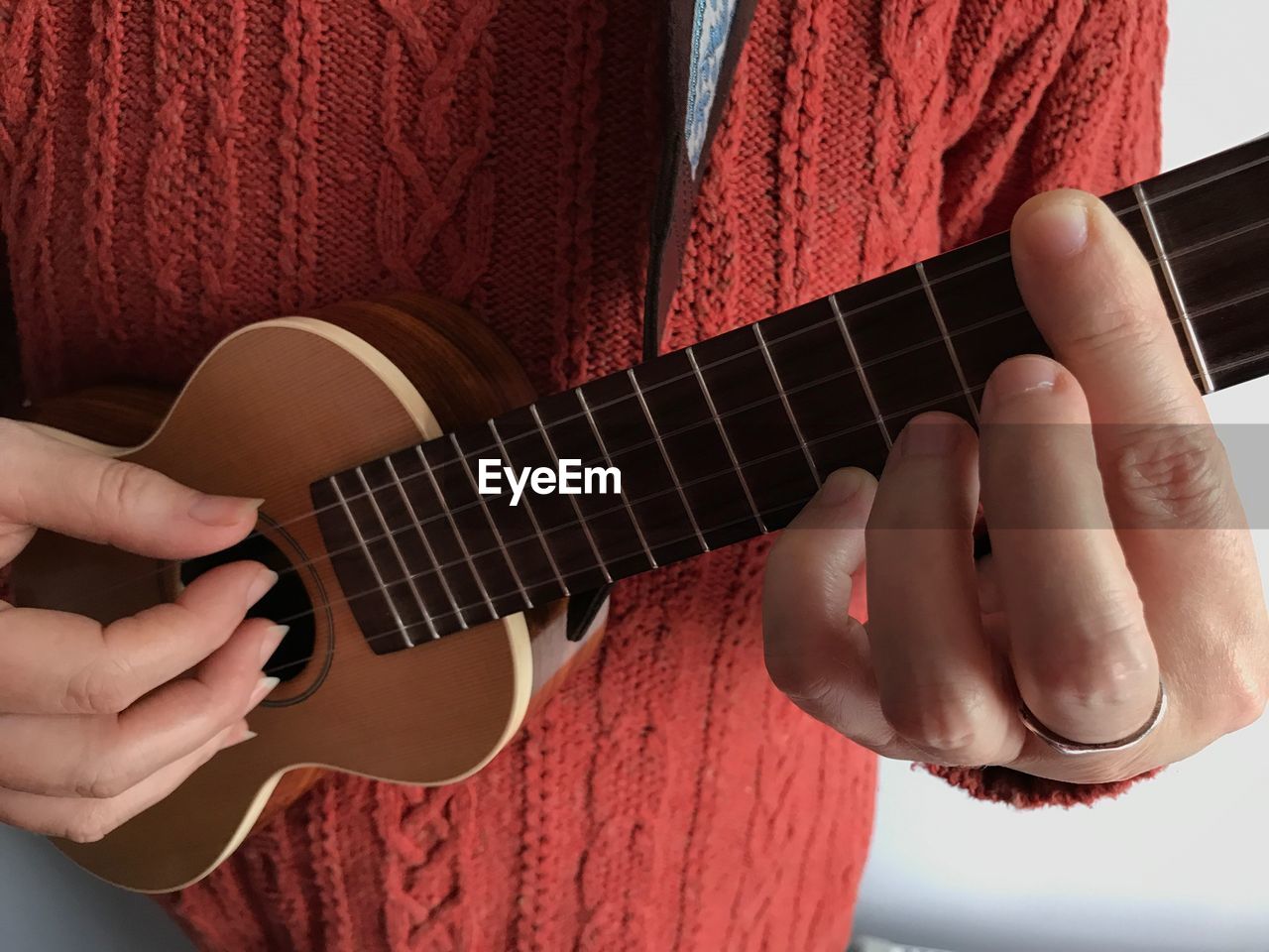 Midsection of woman playing ukelele