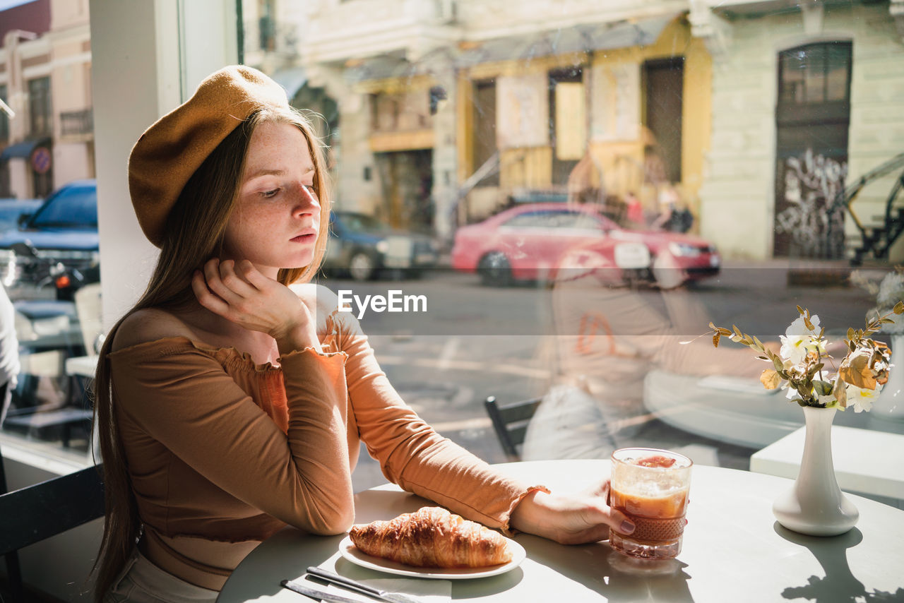 young woman having breakfast at restaurant