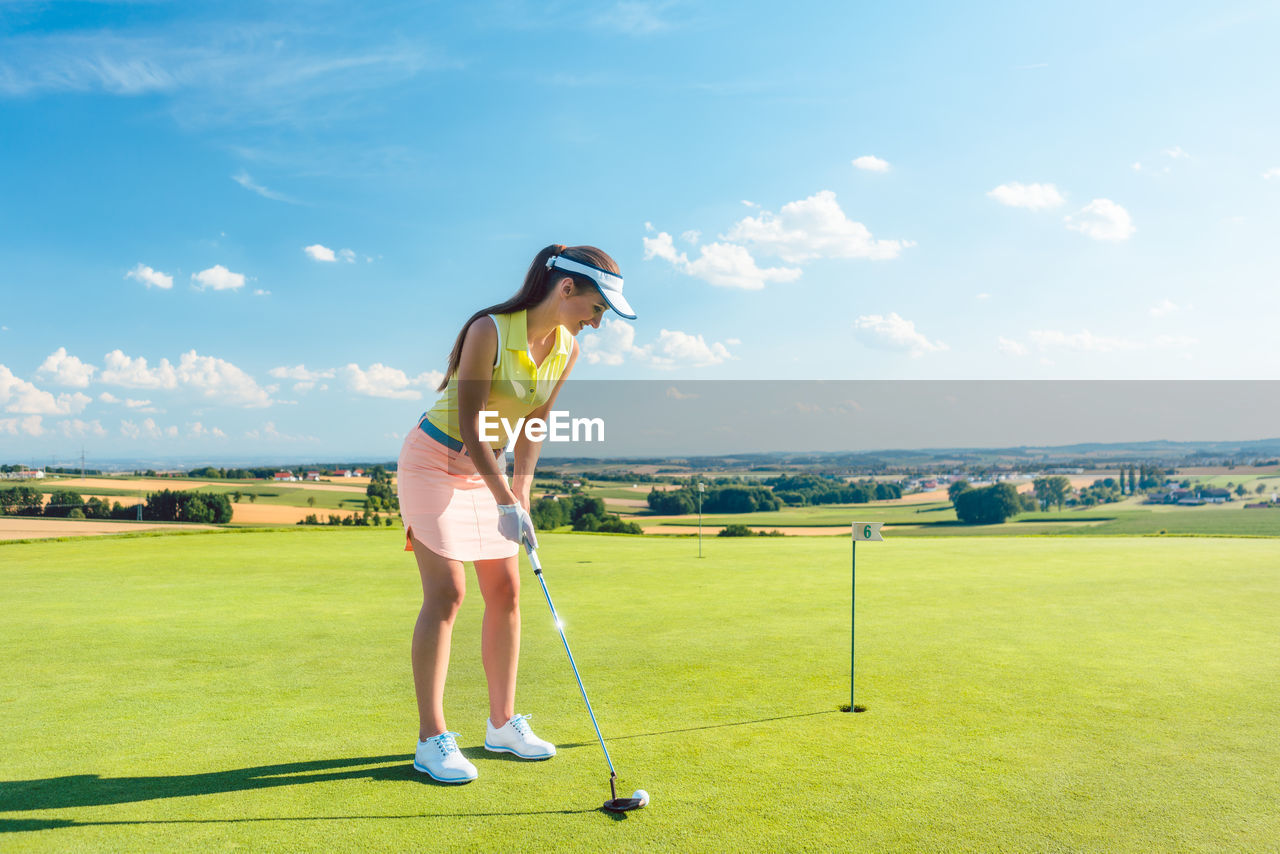 Full length of woman playing golf against sky