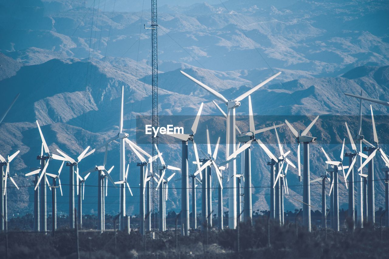 Wind turbines on land against sky