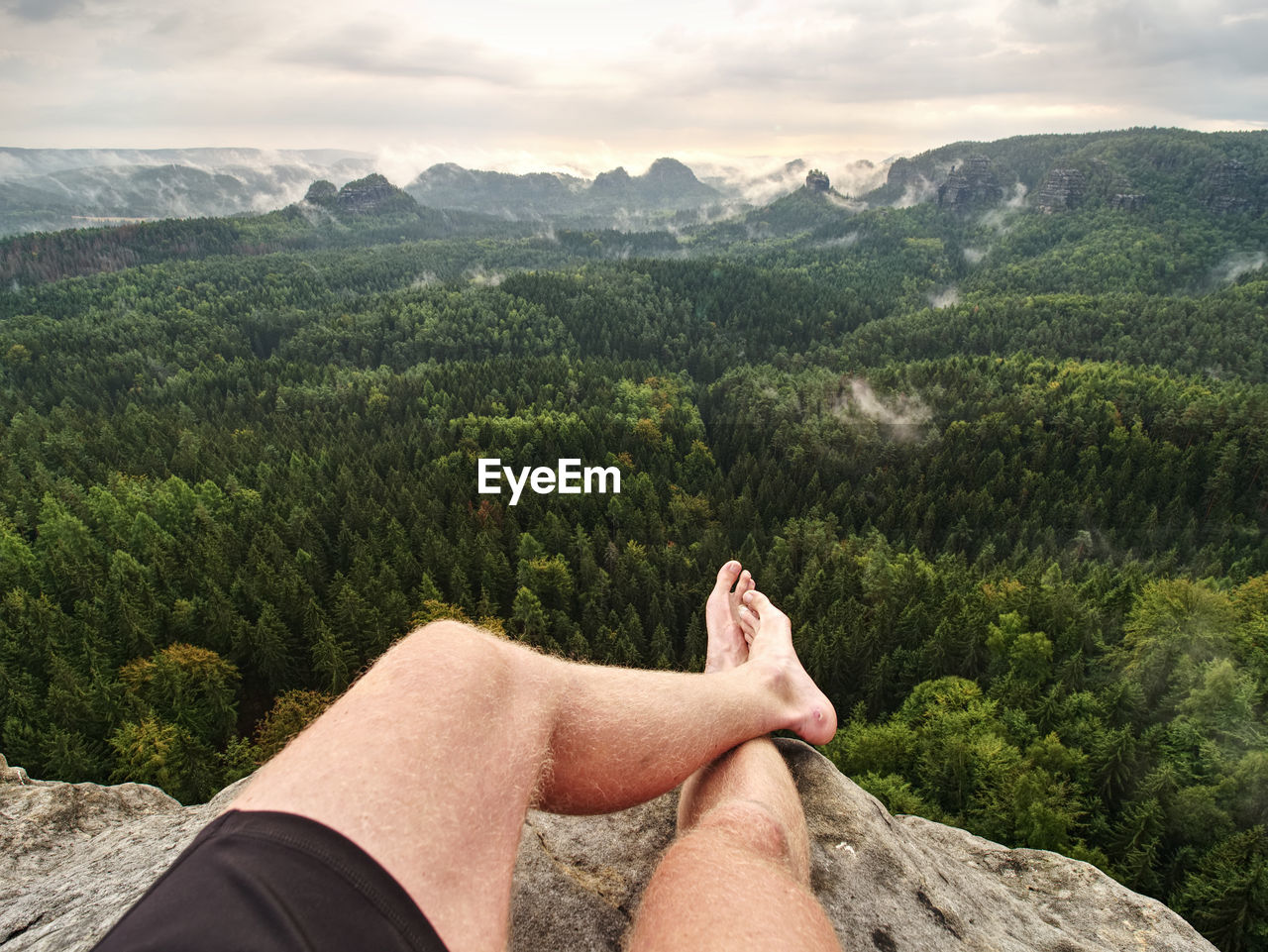 Big bloody callus on man's heel. closeup of man feet relax on rocky summit at edge. man enjoy view