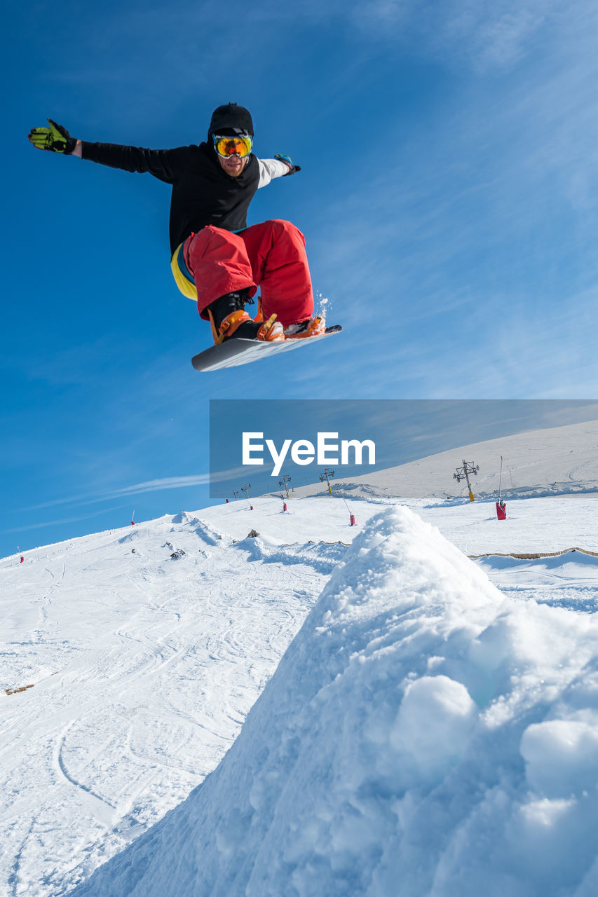 Man jumping with snowboard on landscape