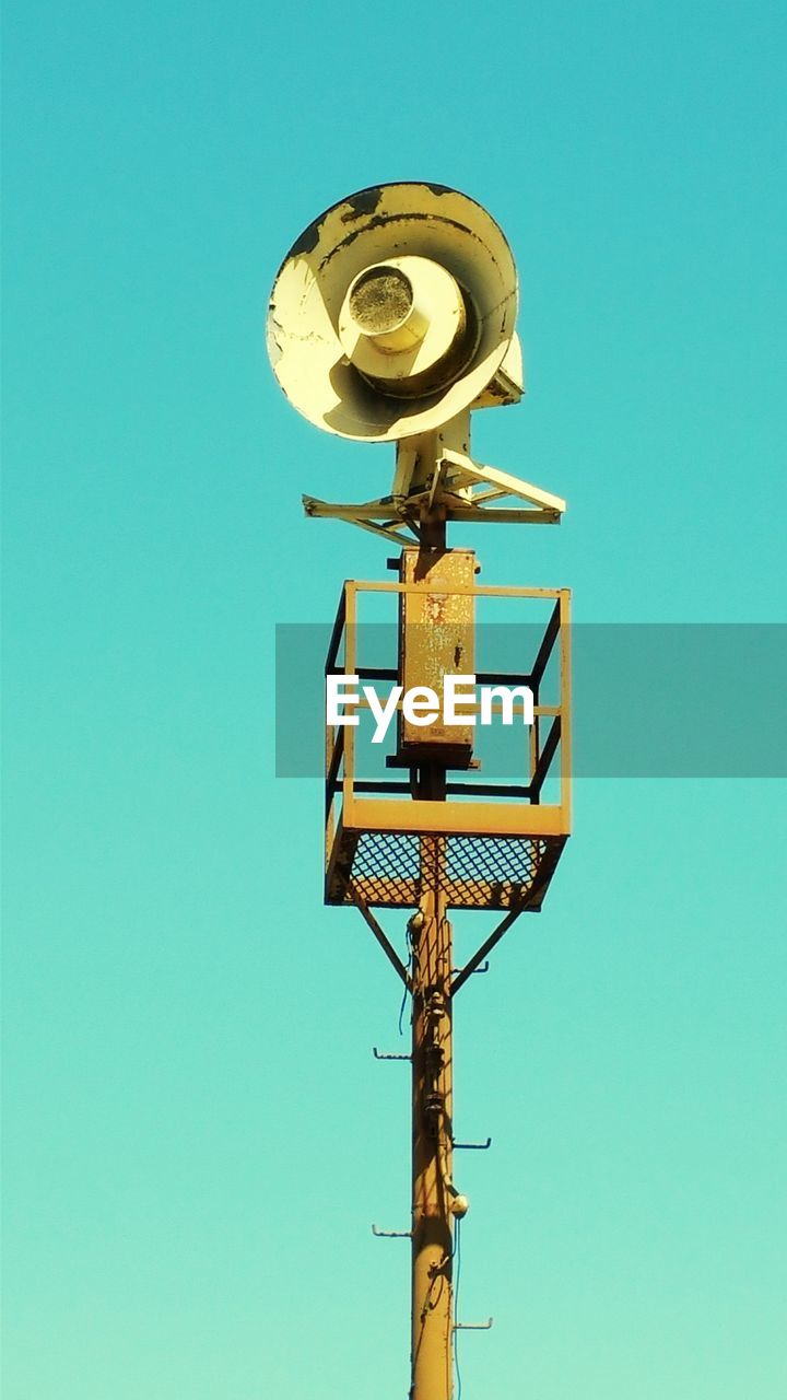 Low angle view of megaphone on pole against clear sky