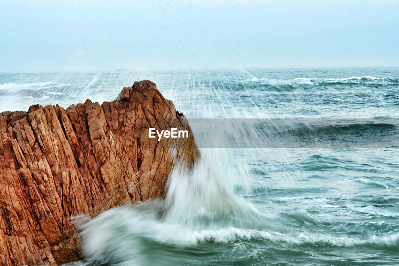 Wave Splashing On Rock Formation In Sea Against Sky On Eyeem