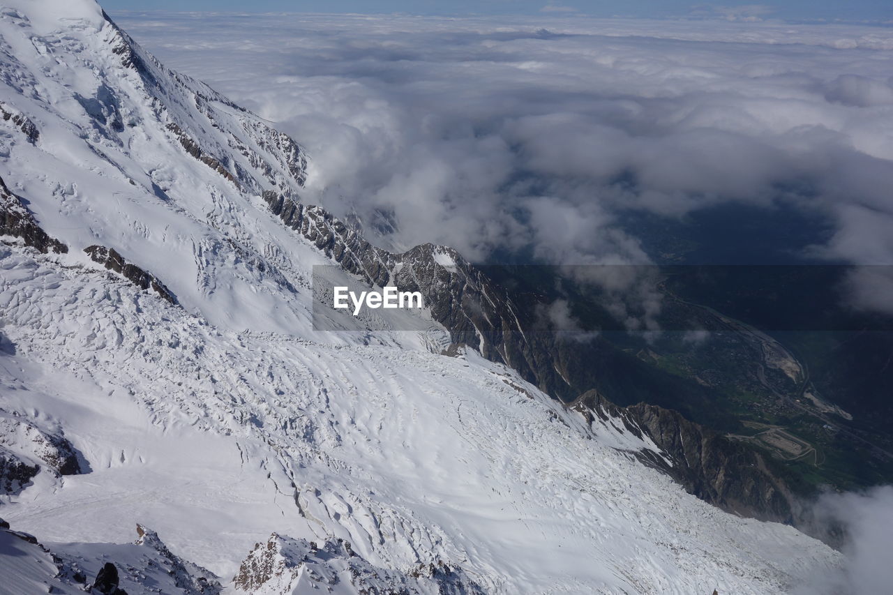 Aerial view of snowcapped mountain against cloudy sky