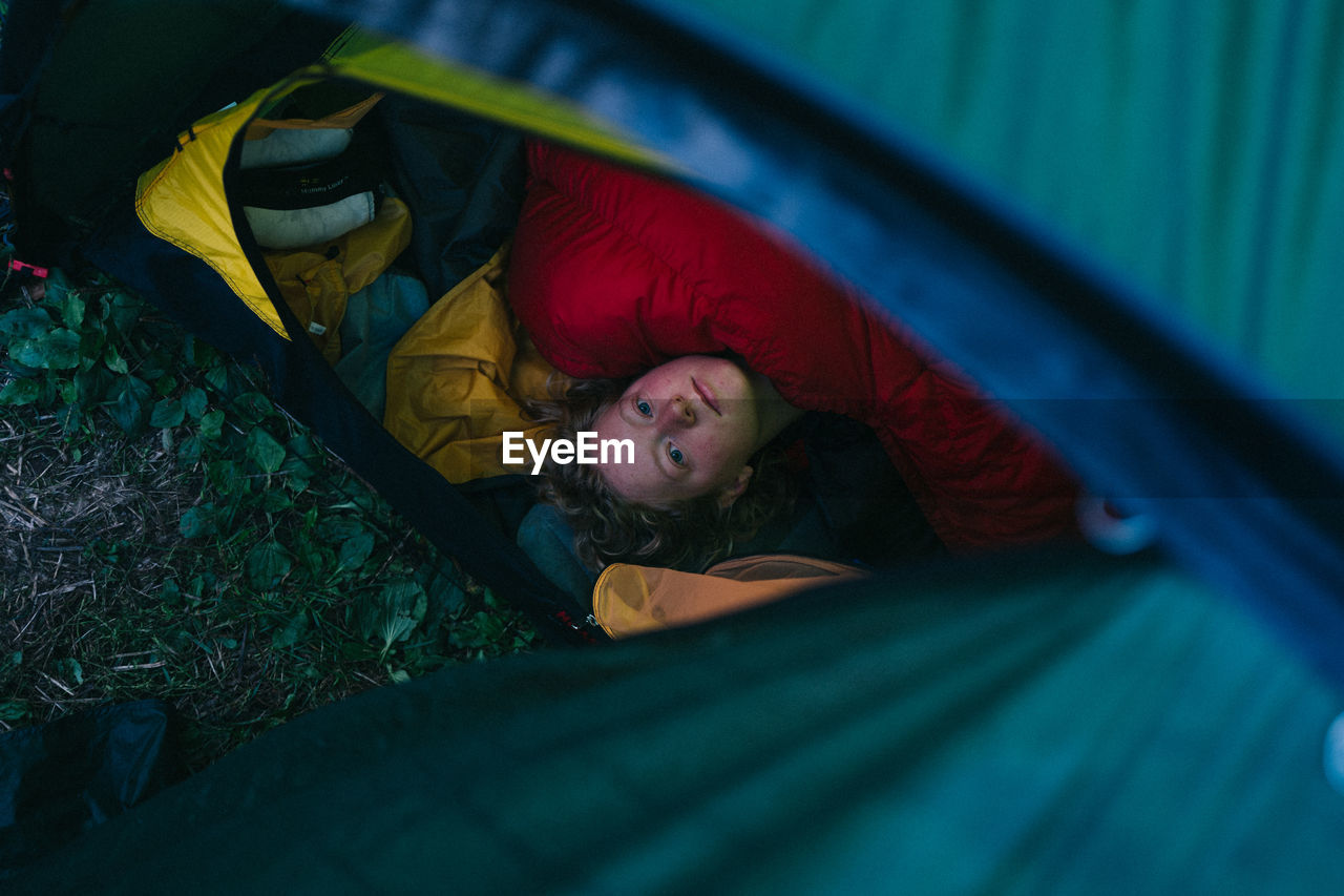 High angle view of woman lying in tent