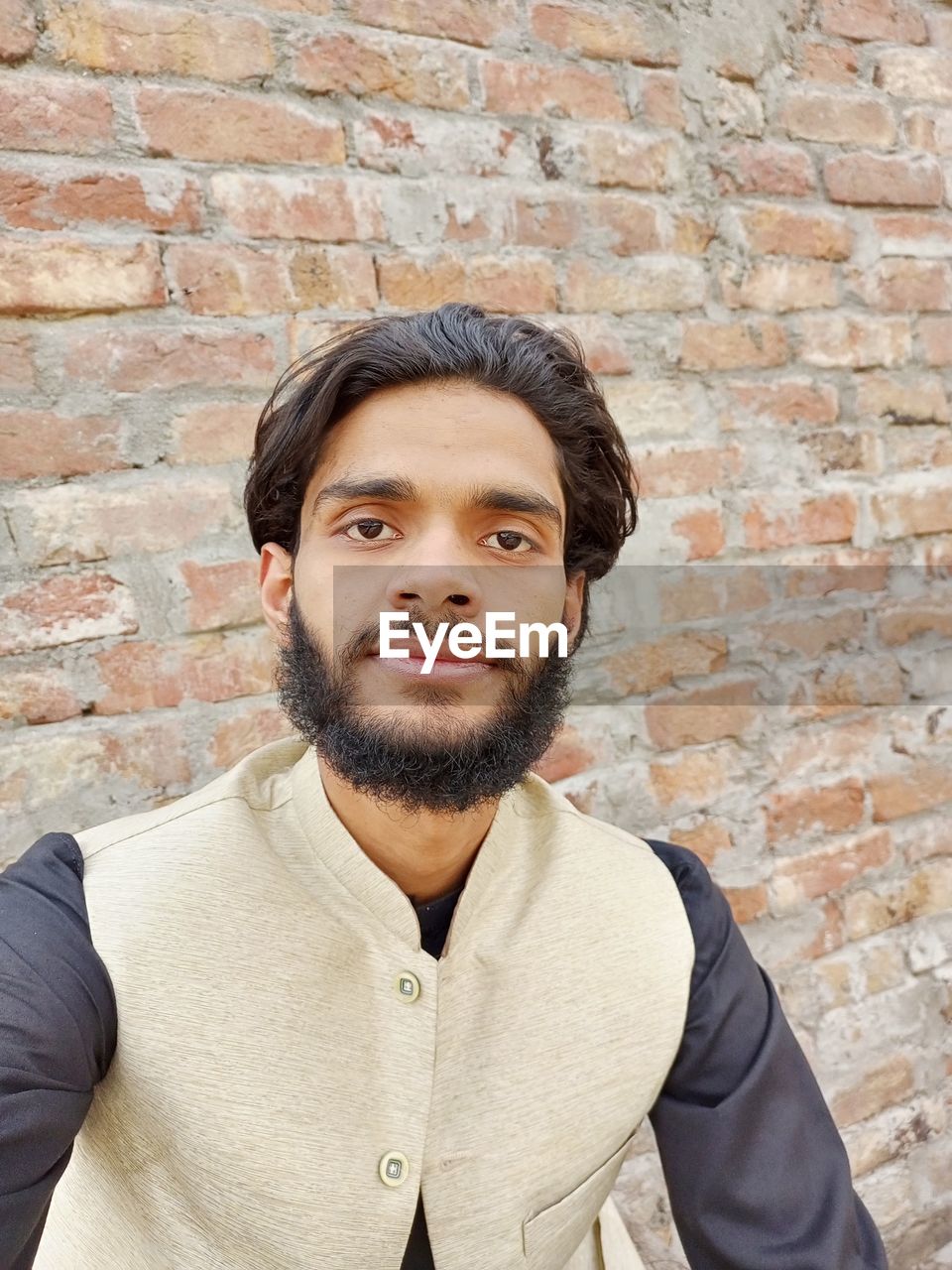beard, facial hair, portrait, one person, brick wall, adult, wall, brick, young adult, front view, men, looking at camera, wall - building feature, standing, casual clothing, architecture, lifestyles, person, clothing, smiling, waist up, looking, headshot, hipster, leisure activity, human hair, cool attitude, individuality, happiness, copy space, day, emotion