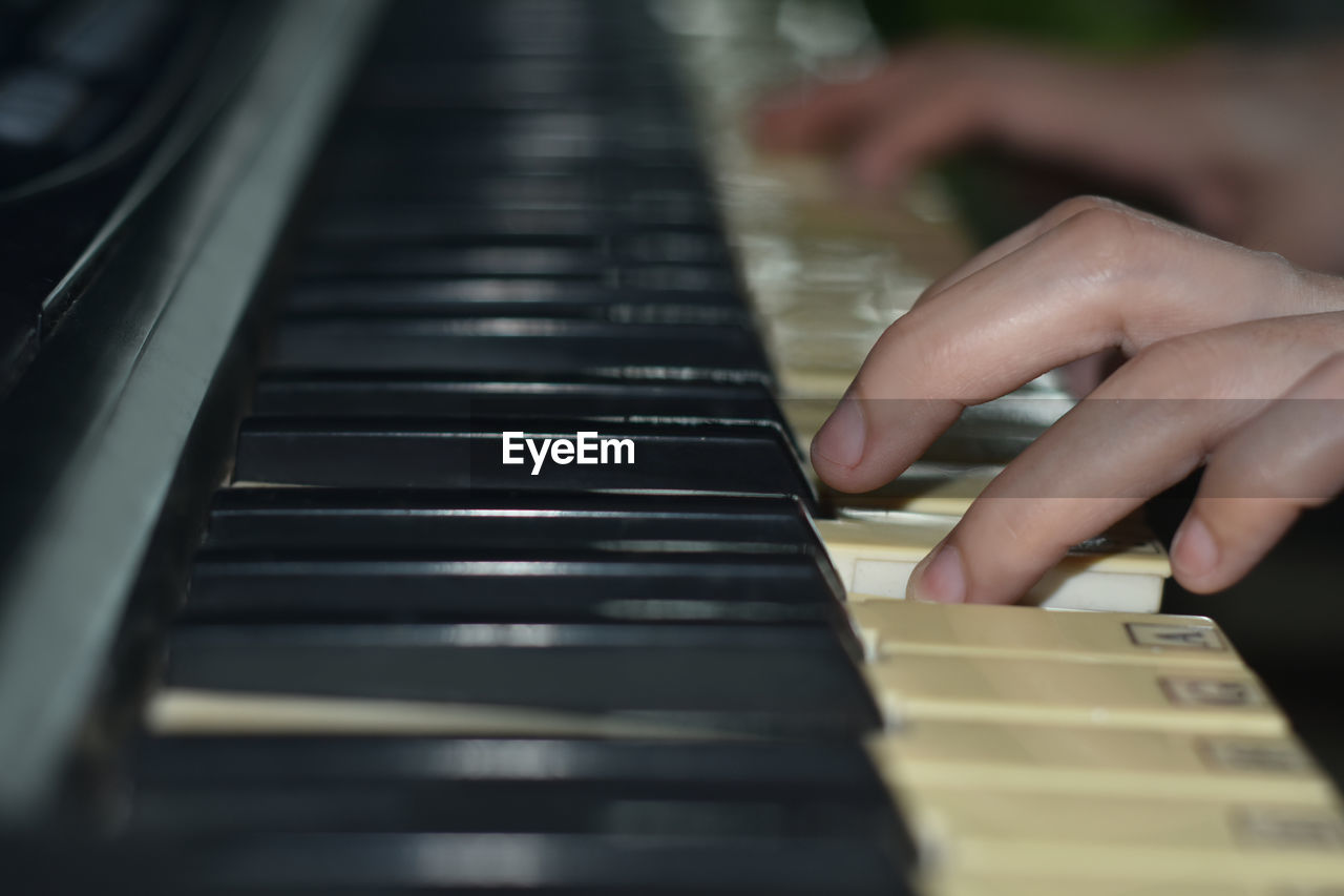 Cropped view of young woman playing keyboard in band