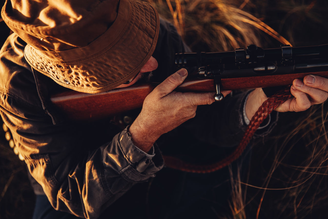 High angle view of man aiming rifle